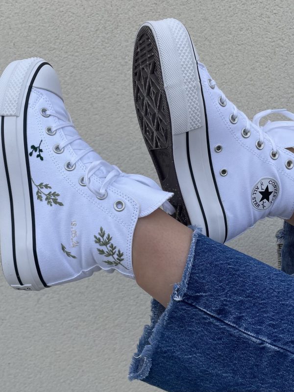 Une paire de baskets personnalisée couleur blanche avec du feuillage vert